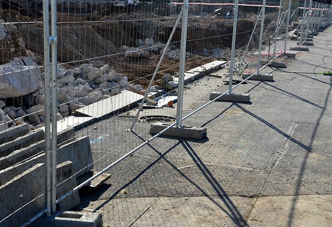 a row of temporary fence panels enclosing a construction site